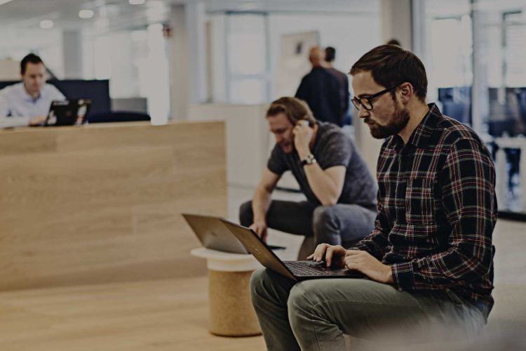 man sitting down working on a laptop